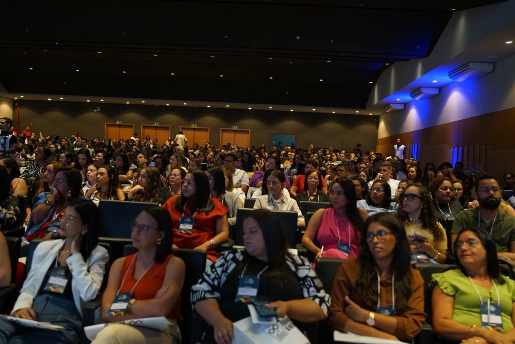 Vista frontal do público do II Seminário Pernambucano de Autismo, com auditório cheio e participantes acompanhando a programação.