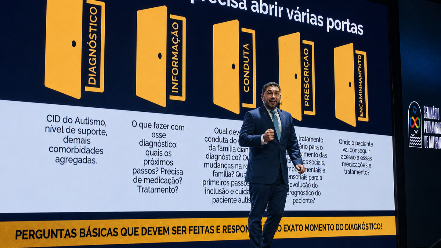 Homem de terno azul, ao fundo um telão.